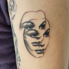 a woman's arm with a tattoo on it that has a drawing of a man's face