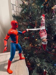 a spiderman toy is hanging from a christmas tree