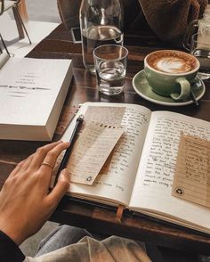 a person sitting at a table with an open book and pen in front of them