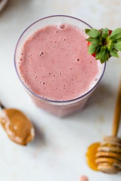 a smoothie in a glass with a strawberry on top