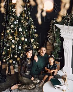 a family sitting in front of a christmas tree