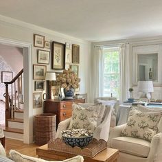 a living room filled with furniture and pictures on the wall