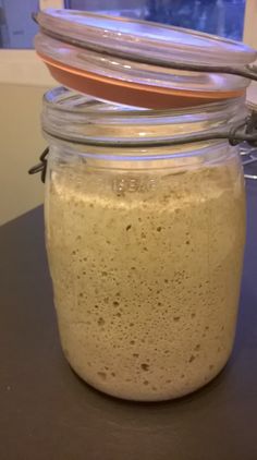 a glass jar filled with liquid sitting on top of a table