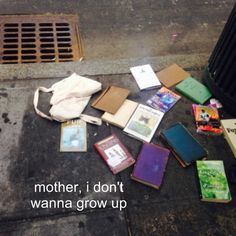 many books are laying on the ground next to a grate