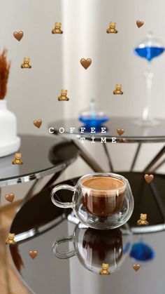 a cup of coffee sitting on top of a glass table with hearts flying around it