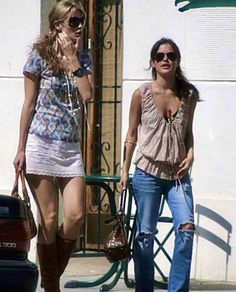 two women walking down the street talking on their cell phones