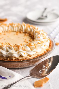 a pie sitting on top of a table next to a fork and spoon in front of it