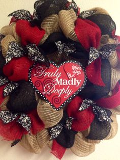 a valentine's day mesh wreath with a red heart on it that says truly madly deeply