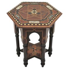 a small wooden table with an intricate design on it's top and bottom shelf