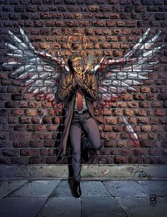 a man standing in front of a brick wall with an angel wings painted on it