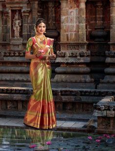 a woman in a colorful sari standing next to a fountain