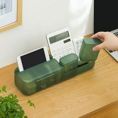 a person using a cell phone holder on a desk next to a laptop and other electronic devices