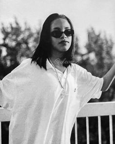 a black and white photo of a woman in sunglasses holding her hand out to the side