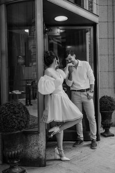 a man standing next to a woman in front of a building