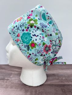 This cap has a light blue background sprinkled with flowers and birds. Teal, Green, and Pink make the perfect, adorable combination. Such a cute, springy vibe! 🌸 I have been a Dental Hygienist for 13+ years.   🦷Since 2020,  I have been making scrub caps for myself and several coworkers to wear for patient care.  I have really enjoyed picking out the fabric and making these caps to bring a little personality to our scrubs!  I developed the pattern myself and cannot wait to share these caps with the rest of the healthcare community!  The 100% cotton fabric has been prewashed and preshrunk.   All seams are finished to prevent fraying.  Made in a smoke free home. I give the option of adding buttons to the sides of the cap to hold your mask, see photos for placement.  (I personally love them Cute Adjustable Light Blue Hat, Whimsical Blue Adjustable Hat, Whimsical Adjustable Blue Hat, Whimsical Blue Hat, Dental Scrubs, Light Blue Background, Medical Scrubs, Surgical Caps, Dental Hygienist