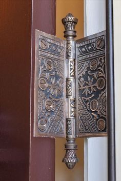 an ornate metal door handle on a wooden door