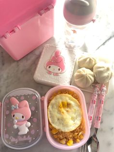 hello kitty bento box lunch with rice and fried egg in the middle, chicken tofu on the side