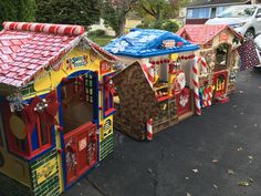 several children's play houses are lined up on the street