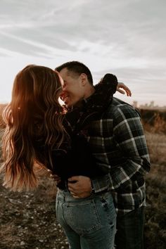 a man and woman kissing in an open field