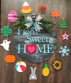 a wooden sign that says home sweet home surrounded by cut out decorations