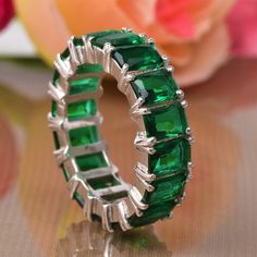 an emerald colored ring sitting on top of a table