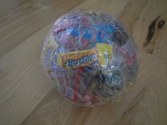 a plastic bag filled with toys on top of a wooden floor