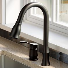 a black faucet sitting on top of a kitchen sink next to a window