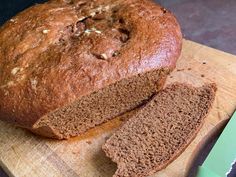 a loaf of bread sitting on top of a wooden cutting board next to a knife