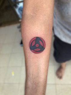 a man with a tattoo on his arm that has a red and black arrow in it