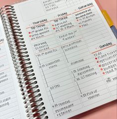 an open planner is sitting on top of a pink table