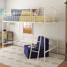 a white bunk bed sitting in a bedroom next to a blue chair and rug on top of a hard wood floor