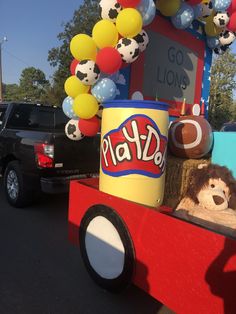 a truck with balloons and stuffed animals in the back