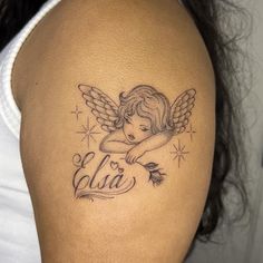 a woman's arm with an angel tattoo on the back of her left shoulder