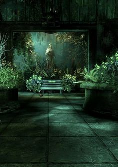 a bench sitting in the middle of a dark courtyard with plants and trees around it