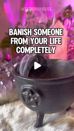 a black bowl sitting on top of a white fur covered floor next to a pink background