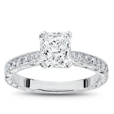 a princess cut diamond engagement ring with diamonds on the band and side stones set in 18k white gold