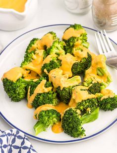 a blue plate topped with broccoli covered in cheese