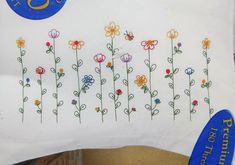 a white pillow with colorful flowers and the letter s on it's front side