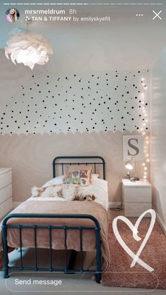 a bed room with a neatly made bed and a heart on the wall above it