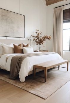 a large bed sitting in a bedroom on top of a hard wood floor next to a window