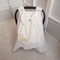 a white chair with a bow on it and the word quiu written in gold