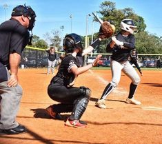 some baseball players are playing softball on a field