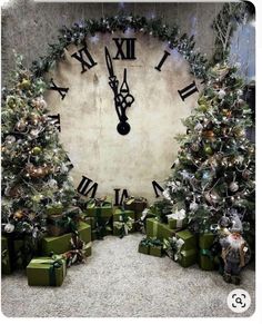 a large clock surrounded by presents and christmas trees