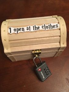 an open wooden box with a padlock attached to it that says, i open at the clothes