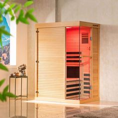 an indoor sauna is shown in the middle of a room with plants on the floor