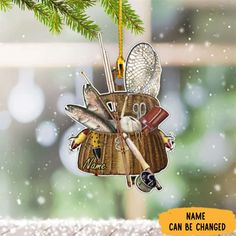 a christmas ornament with fishing gear hanging from it's side on a tree branch