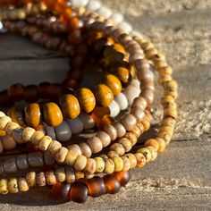 This is a lovely coordinated stack of 6 stretch seed bead and wood bracelets in earthy brown tones. Perfect for dressing up, a casual day out, or no occasion at all! Rearrange the bracelets to get the exact style you like, or add them to some of your existing favorites to customize your accessorizing. Looks fantastic paired with gold. Set includes one each of: deep amber, Picasso matte canary yellow, Picasso matte brown, off-white/stone solid color, metallic khaki, and one wood bead bracelet.  As a handmade item, each set will vary slightly due to randomization of patterns.  Giving as a gift? The 7" size is considered "standard" and fits a lot of teens and adults. Treating yourself? Measure your wrist to choose your desired size. Selecting a set that's a little larger means the stack will Bead Bracelet Stack, Wood Bead Bracelet, Earthy Brown, Seed Bead Bracelet, Wood Bracelet, Canary Yellow, Brown Tones, Shades Of Brown, Seed Bead Bracelets