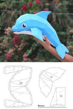 the paper dolphin is being held up by someone's hand