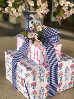 two gift boxes wrapped in blue and white paper with pink flowers