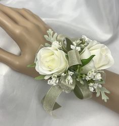 a bridal bouquet with white roses and baby's breath on a mannequin